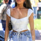 Woman wearing a white top and light blue jeans outdoors